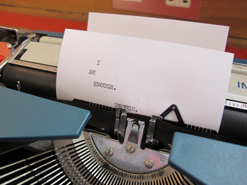 Photo of typewriter, typing: "I am enough. Enough."