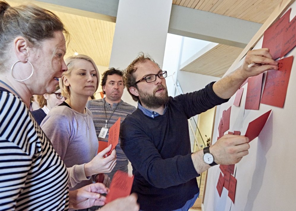 Photo of people sticking notes to whiteboard