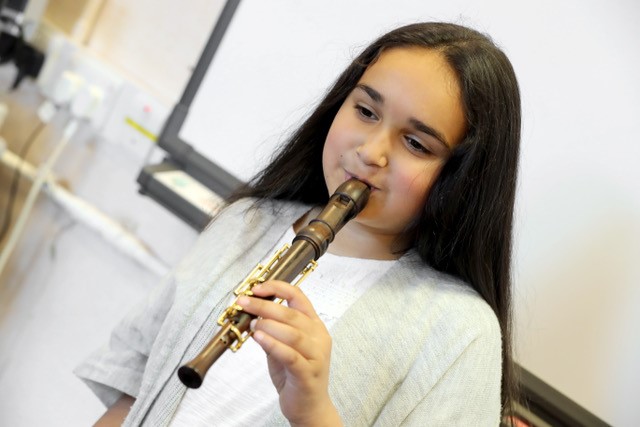 Photo of a girl playing a one-handed recorder