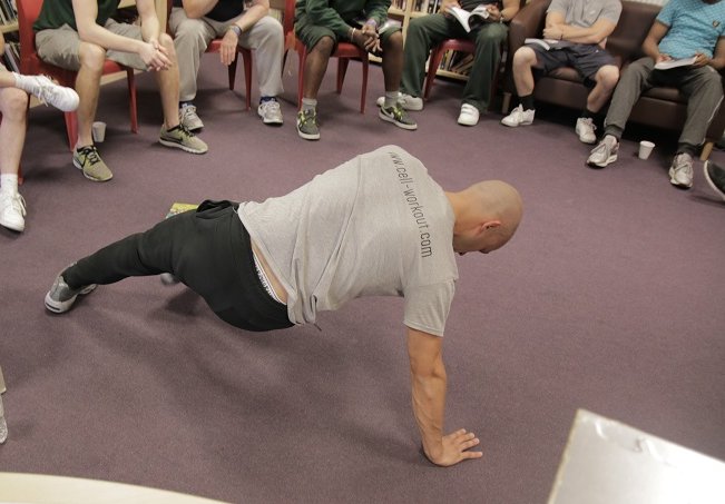 Photo of man breakdancing with people sitting round