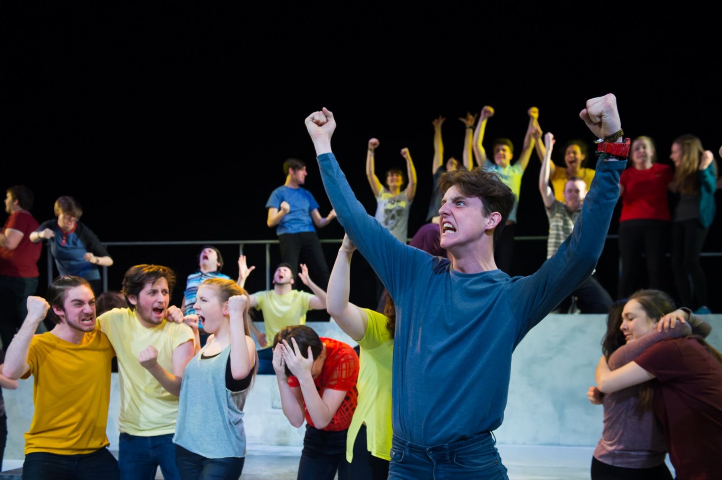 Photo of crowd of young people with man raising his arm