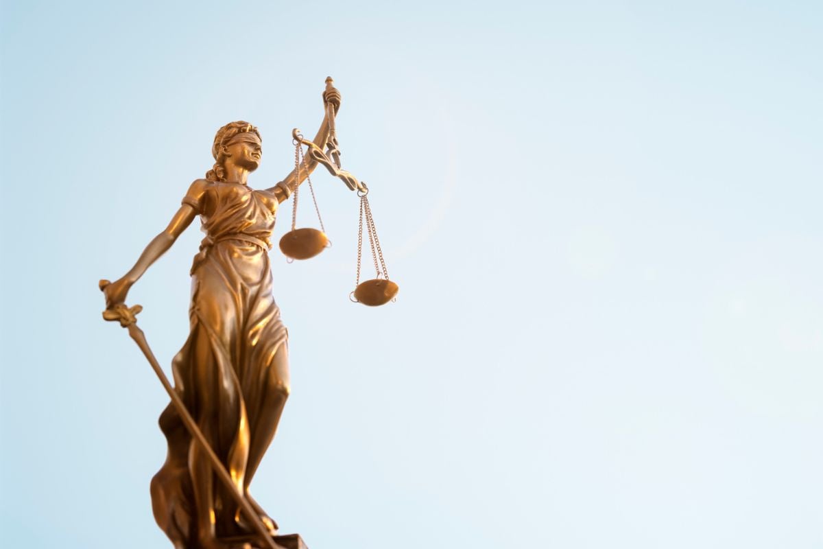 Legal law concept statue of Lady Justice with scales of justice sky background stock photo