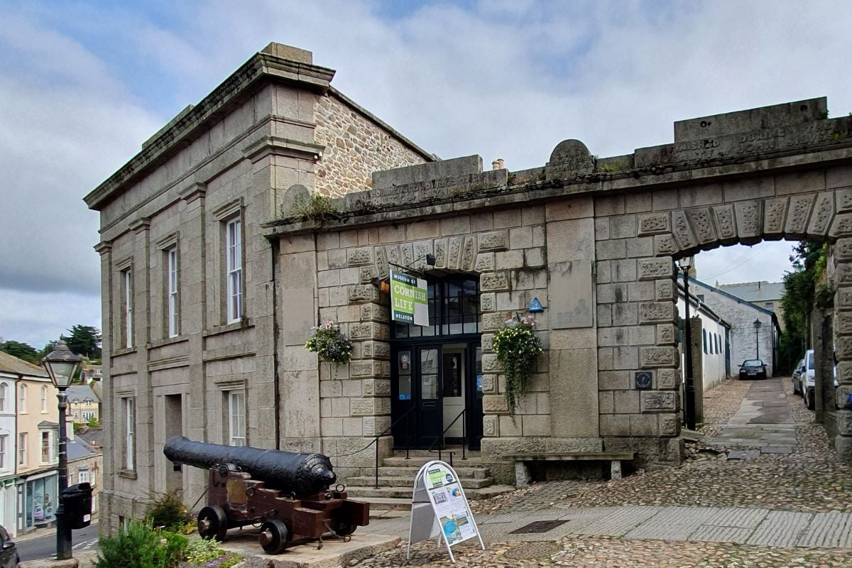 Wikimedia Museum of Cornish Life, Market Place, Helston, Cornwall - August 2024. Grade II Listed items... Museum and entrance Screen, Market Place steps and paving, gun from HMS Anson.
