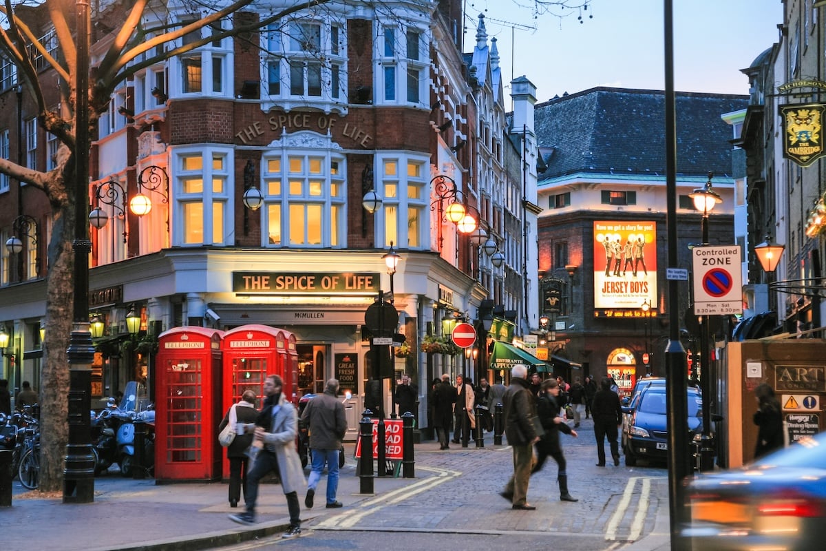 LONDON, UK - JANUARY 20, 2009: view of people, bars, restaurants on crossing Moor st and Romilly st from Charing Cross Road of Soho district of City of Westminster in London winter evening.