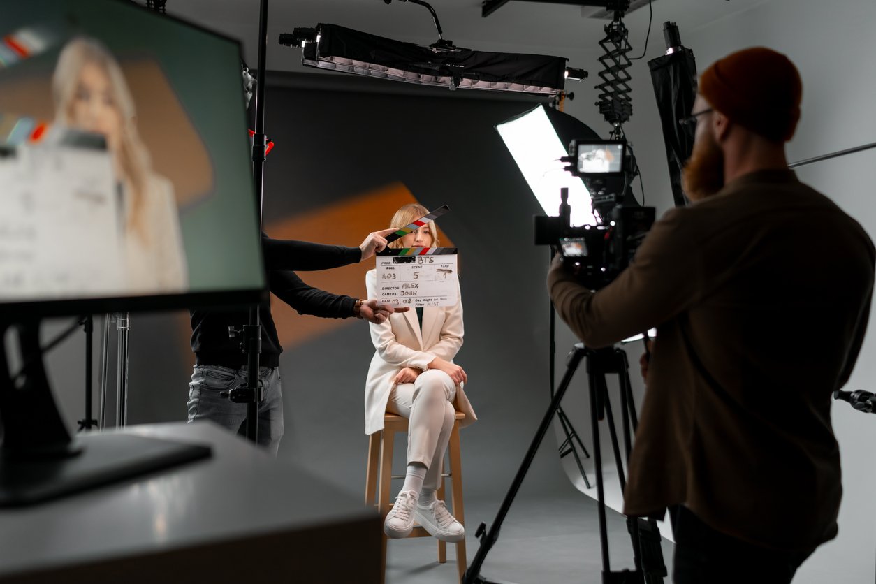 A man is using a clapper board as a gesture in front of a woman, displaying a fun event in the room.