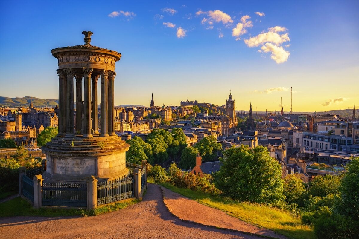 Golden sunset view from Calton Hill with Dugald Stewart Monument overlooking the historic Edinburgh skyline  in Scotland.