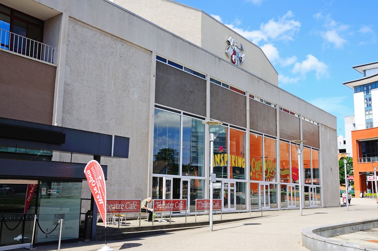 Coventry, United Kingdom - June 4, 2015: Belgrade Theatre in Belgrade Square with people relaxing in the sunshine, Coventry, West Midlands, England, UK, Western Europe.