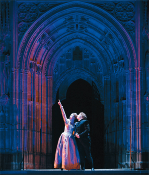 A couple in victorian costume, stand on stage in Canterbury Cathedral