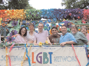 A group of people stand on a brightly coloured float