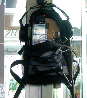 An IPod and headphones are strapped to a post