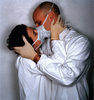 Two doctors in surgeon's masks kiss