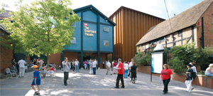 The exterior of the Courtyard theatre, people mill around outside on a summers day