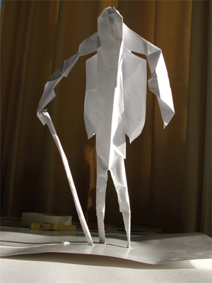 A large origami paper model of a man with a walking stick