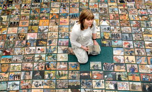 A lady sits on floor surrounded by postcards