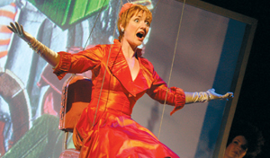 A lady sits in a swing on stage, singing