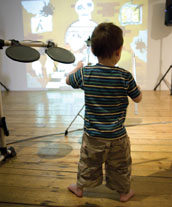 A toddler plays the drums
