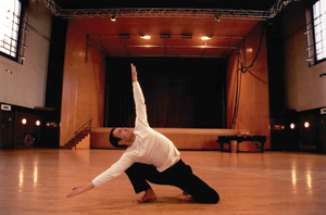 Male dancer posing on the floor in a large studio