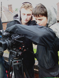 Two young boys looking through a camera