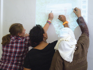 3 woman drawing on a projector screen