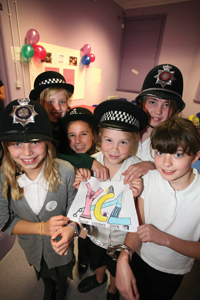 Young children wearing policeman hats