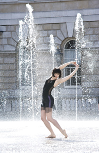 Girl in a black dress, dancing inbetween fountains