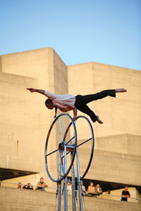 Man balancing on a wheel with one hand