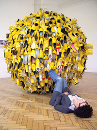 Girl laying on floor with her feet up leaning against a big ball of yellow shoes
