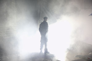 Image of a soldier, standing on an atmospheric misty lit up stage