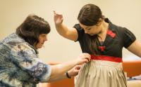 Assistant stage manager Teresa Morrow applies finishing touches to a costume worn by actor Sara Billeaux.