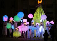 Photo of dancers in brightly lit colours in nighttime show