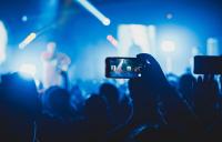 A photo of a smartphone being held up in a concert audience