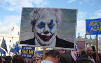 protest sign showing Boris Johnson in clown makeup