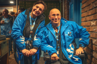 volunteers during Coventry's City of Culture year. two volunteers are facing the camera, smiling, wearing blue City of Culture branded jackets