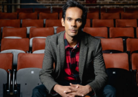 Photograph of Suba Das, Creative Director of Liverpool Everyman and Playhouse, seated within an auditorium, surrounded by audience seats.