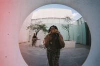 Aliyah Hasinah is taking a picture in a round mirror.