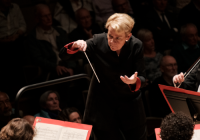 Marin Alsop conducting, 29 Sep 2022. She wears a long black coat and holds a baton. She has short blonde hair.