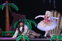 A performance of a pantomime. A man dressed as a pirate lies on the floor with a woman in a tutu dancing beside him