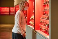 Woman wearing a face mask views an exhibition in a museum