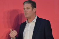 photo of Keir Starmer delivering a speech in front of a red background