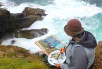 A person sitting at the edge of a cliff painting a picture of waves crashing against rocks below