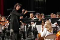 Conductor leading a school orchestra