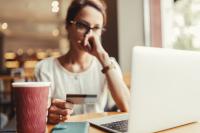 Woman debating online purchase with credit card