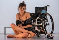 Diana performing on the floor in front of her wheelchair