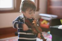 A young boy with a micro violin
