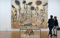 Couple viewing a painting and sculpture by Anselm Kiefer