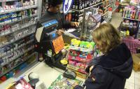 woman buying a lottery ticket in a shop