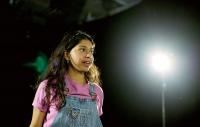 a girl standing on stage in a spotlight