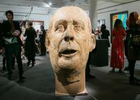 Photo of sculpture of large head in gallery
