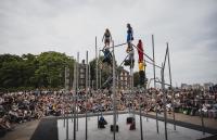 A photo of people standing on a tall metal structure on a stage