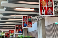 Wise Woman exhibition in Leeds School of Arts. The photo depicts five frames hung from the ceiling, each with four portraits of female researchers looking at the camera